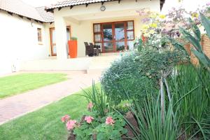 a house with a garden with pink flowers in the yard at Topaz Cove Luxury Villas in Edenvale