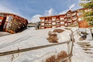 a snow covered building in front of a building at La Bouillandire in Les Gets