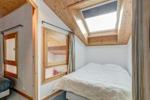 a small bedroom with a bed and a window at La Bouillandire in Les Gets