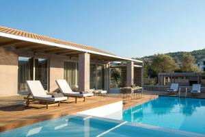 a patio with chairs and a swimming pool at Agrikies Villas in Lefkada