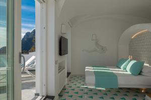 a bedroom with a bed and a balcony at Petrea Lifestyle Suites in Positano