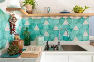 cocina con fregadero y pared de azulejos en Petrea Lifestyle Suites en Positano