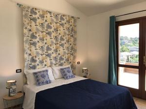 a bedroom with a blue bed and a window at Sa Tirìa in Chia