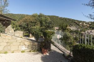 a fence next to a stone wall with a tree at Sa Tirìa in Chia