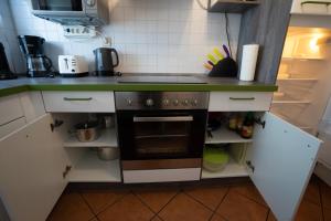 Il comprend une petite cuisine avec des placards blancs et une cuisinière. dans l'établissement Fewo Reutlingen Metzstraße OG 1, à Reutlingen
