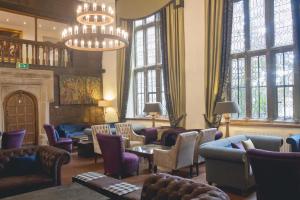 
a living room filled with furniture and a piano at Boringdon Hall Hotel and Spa in Plymouth
