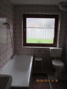 uma casa de banho com uma banheira branca e uma janela em Haus Bergfrieden em Achenkirch