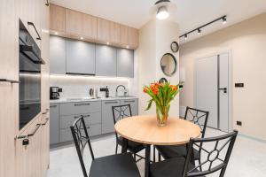 a kitchen and dining room with a table and chairs at BG Premium Apartments Mennica Residence in Warsaw