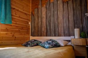 a bedroom with a bed with a wooden wall at Rajskie Domki in Sadowie
