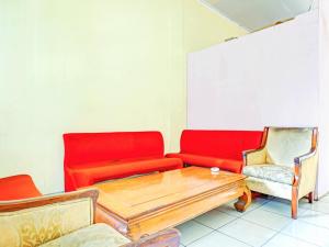 a room with a couch and a table and chairs at Penginapan Marsya Prima Syariah in Jakarta