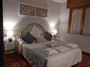 Un dormitorio con una cama grande con almohadas azules. en ARCO DE VILLAHOZ, en Villahoz 12 fotos más