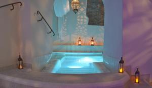 una vasca idromassaggio in una stanza con luci e candele di Hotel Al Convento a Vezzano Ligure