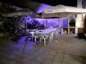 un grupo de mesas y sombrillas en un patio por la noche en ARCO DE VILLAHOZ, en Villahoz