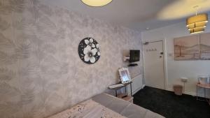 a bedroom with a bed and a clock on the wall at The Weeton guesthouse in Blackpool