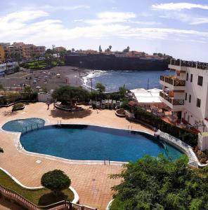 a large swimming pool in front of a beach at Apartamento Neptuno playa 12 in Puerto de Santiago