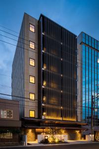 un edificio alto con luces delante en GRAND BASE -Nagoya Chiyokura- en Nagoya