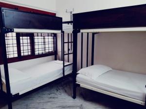 two bunk beds are in a room with at The Hood Hostel in Bangalore