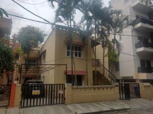 un edificio con una palmera delante de él en The Hood Hostel, en Bangalore