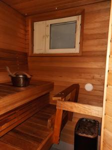 un sauna avec un banc et une fenêtre dans l'établissement Lapin Kutsu Luulampi Apartments, à Saariselka