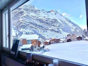 uma janela com vista para uma montanha coberta de neve em Studio MIA - Cosy & Comfortable - Glacier Paradise em Zermatt