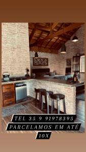 a kitchen with a table and chairs in a room at Chalé Villa Magrini in Monte Verde