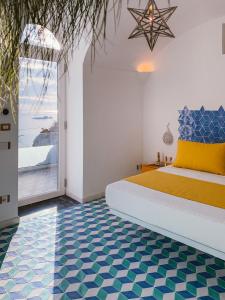 a bedroom with a bed with a blue and white floor at Petrea Lifestyle Suites in Positano