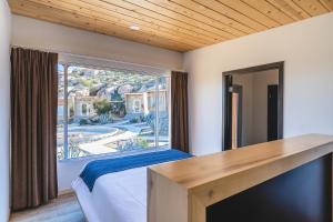a hotel room with a bed and a window at Oeno Wine Lodge in Valle de Guadalupe