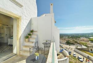 a view from the balcony of a house with stairs and tables at Sunshine Luxury Rooms in Ostuni
