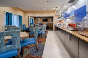 ein Restaurant mit blauen Stühlen und einer Theke in der Unterkunft Holiday Inn Express St. Paul South - Inver Grove Heights, an IHG Hotel in Inver Grove Heights