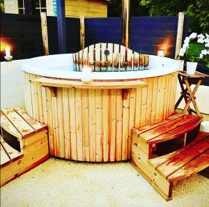 - un bain à remous en bois avec deux bancs autour dans l'établissement L'Orée du Mans, à Sillé-le-Philippe