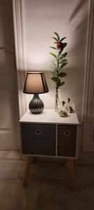 a table with a lamp and a vase of flowers on it at la CASITA DEL CORAZON in Castillo del Romeral