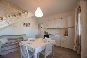 a living room with a table and a kitchen at Villa Girasole in Valledoria