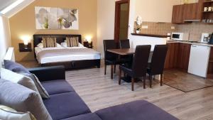 a living room with a couch and a bed and a table at Gellény Lux Apartman in Gyula