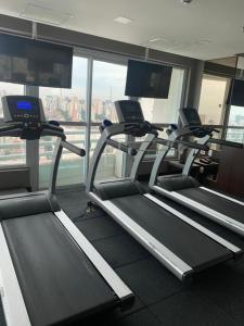 a gym with several tread machines in a building at Hotel Cadoro São Paulo in Sao Paulo
