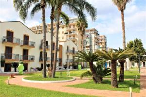 un edificio con palme di fronte ad esso di Casena Dei Colli, Sure Hotel Collection By Best Western a Palermo