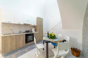 a kitchen with a table with chairs and a sink at VaVillaVà Appartamenti in Centro in Marsala