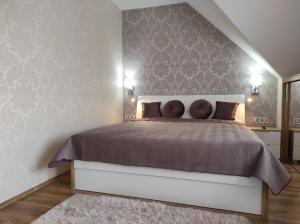 A bed or beds in a room at Lelle Central Grand Apartman