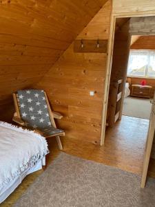 a room with a bed and a chair in a attic at Avoti in Jūrkalne +81 photos