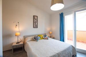 ein Schlafzimmer mit einem Bett mit zwei Lampen und einem Fenster in der Unterkunft Villa Girasole in Valledoria