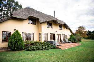 a thatch roof house with a thatched roof at Graceland Farm in Underberg