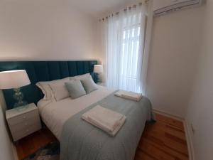 a bedroom with a bed with two towels on it at Sintra Lux Home in Sintra