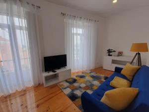 a living room with a blue couch and a tv at Sintra Lux Home in Sintra