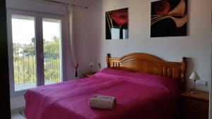 a bedroom with a bed with a purple blanket and a window at Rosalalinda - cosy semi-detached home with sea views and large terrace in Moraira +13 photos