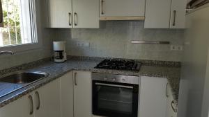 a kitchen with a stove top oven next to a sink at Rosalalinda - cosy semi-detached home with sea views and large terrace in Moraira