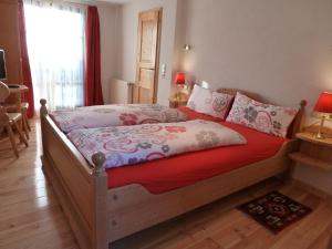 um quarto com uma cama com um edredão vermelho em Pfälzer Landhotel Heinrich em Bad Dürkheim