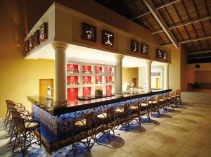 a bar in a restaurant with a bunch of chairs at Occidental Caribe - All Inclusive in Punta Cana