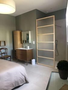 um quarto com uma cama e uma casa de banho com um lavatório em La Maison de Laurie em Pézenas