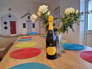 eine Flasche Wein auf einem Tisch mit Blumen in der Unterkunft Admiralty House in Weymouth + 20 Fotos