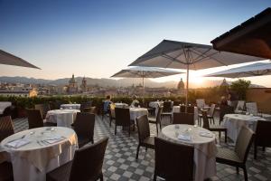 un restaurante con mesas y sombrillas en un patio en Hotel Ambasciatori, en Palermo