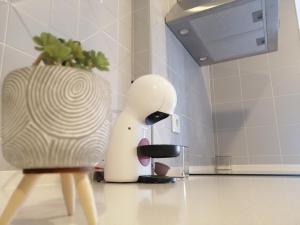 um aparelho branco sentado num balcão de cozinha ao lado de um vaso em Casa do Frade em Cabeço de Alhos Vedros